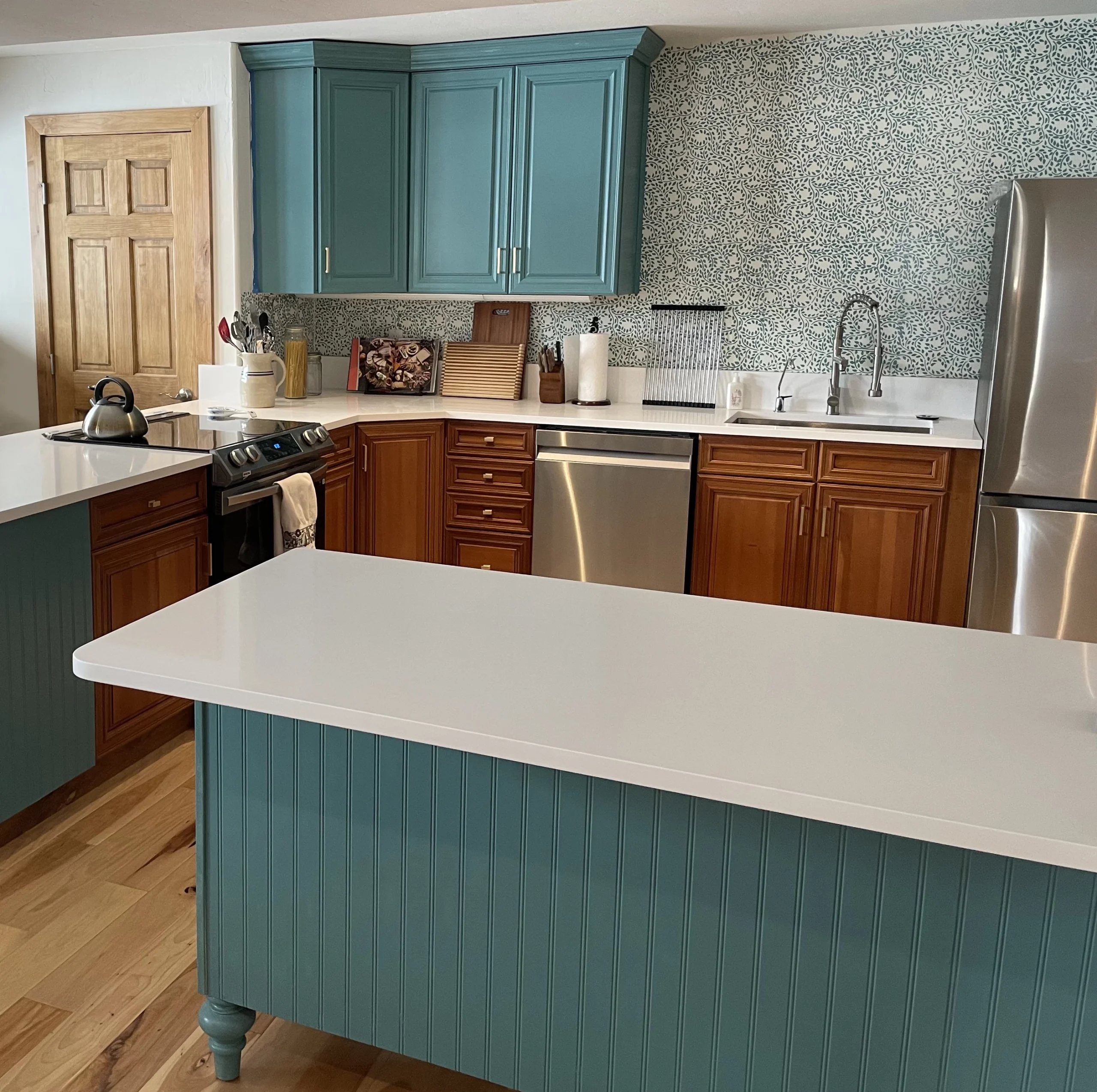 Beautiful kitchen with aqua painted cabinets over finished wood lower cabinets